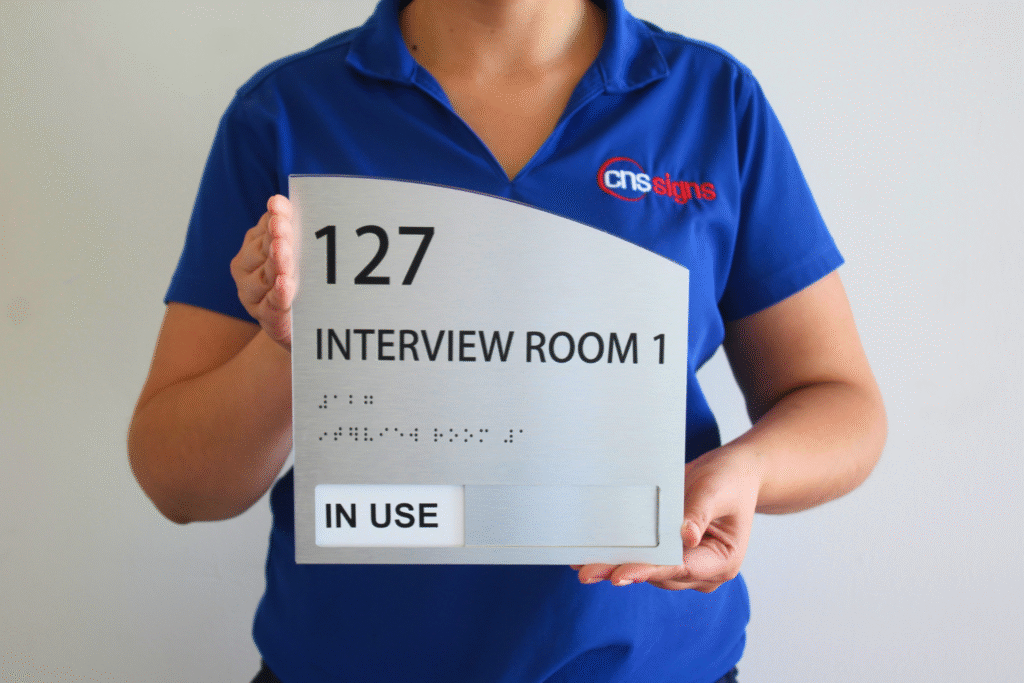 Brushed aluminum ADA braille sign, interview room 127